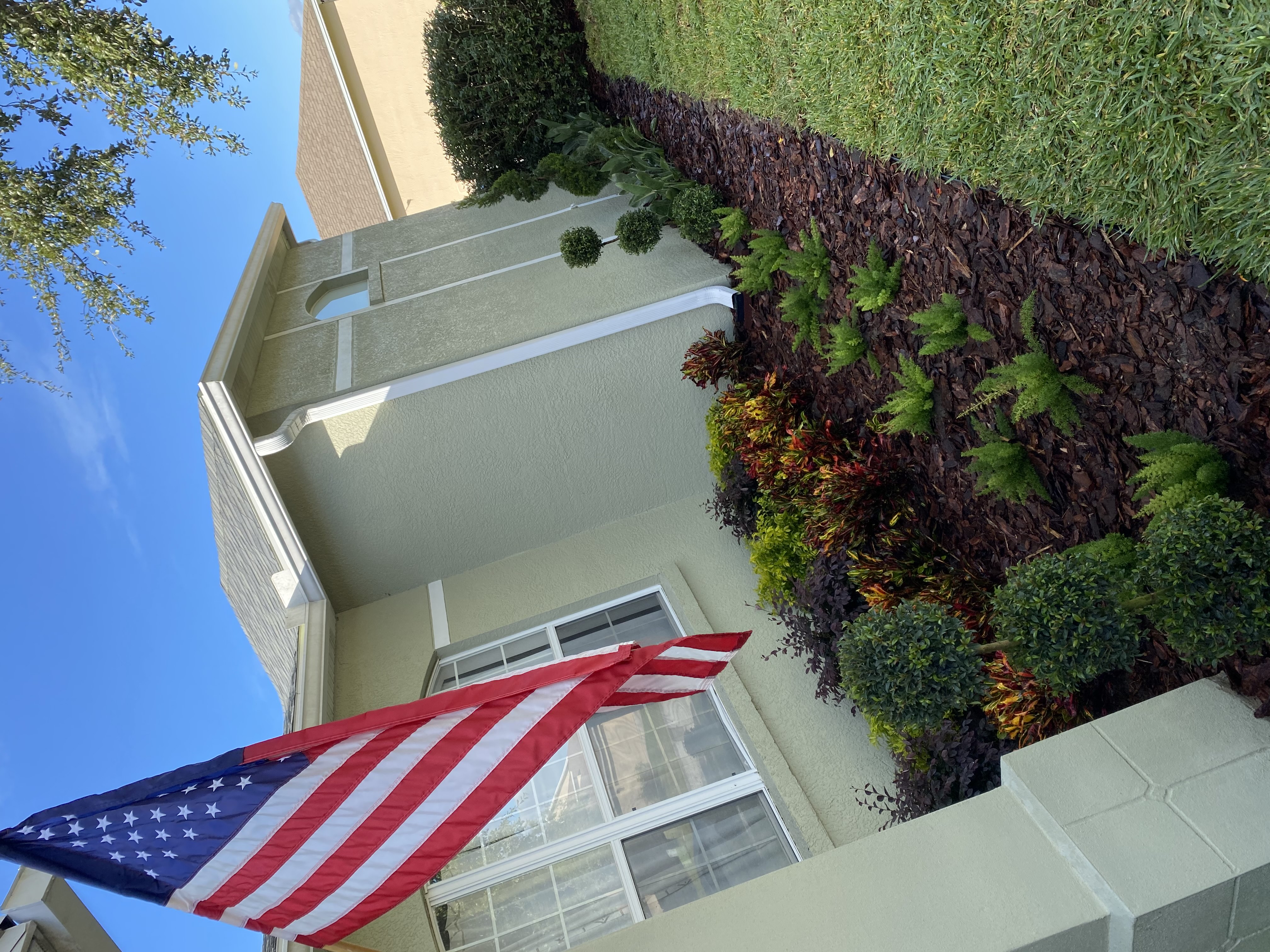Papo Nurseries shows off their beautiful front garden landscape design next to the all American flag
